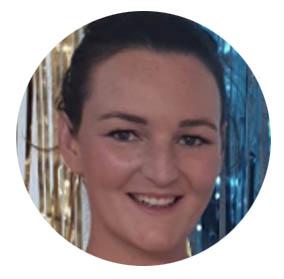 Smiling person against a background of blue and gold streamers.