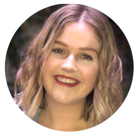 Smiling woman with wavy blonde hair against a blurred natural background.
