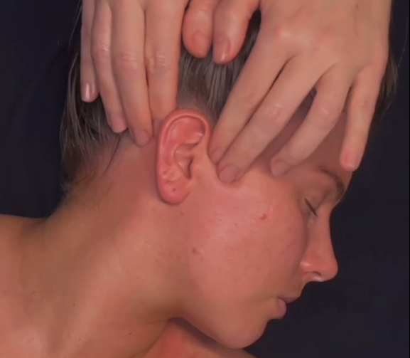Therapist gently massaging a client's temple at Renew You studio.