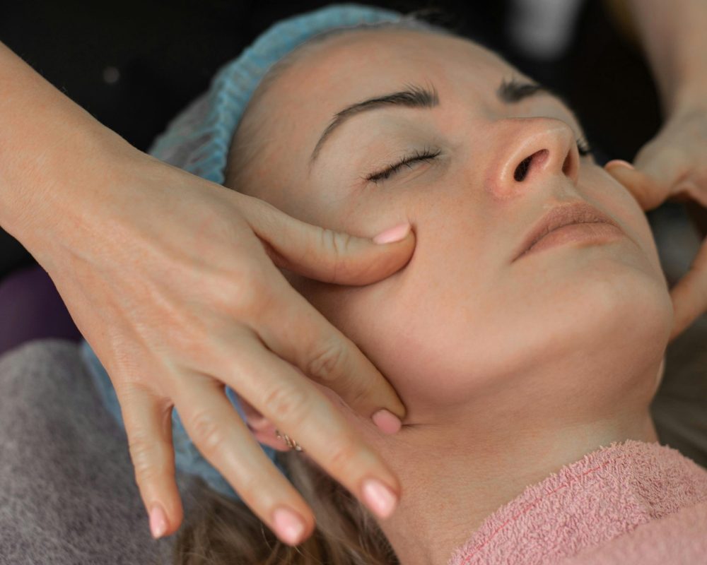 Therapist gently massages client's face during a relaxing facial treatment.