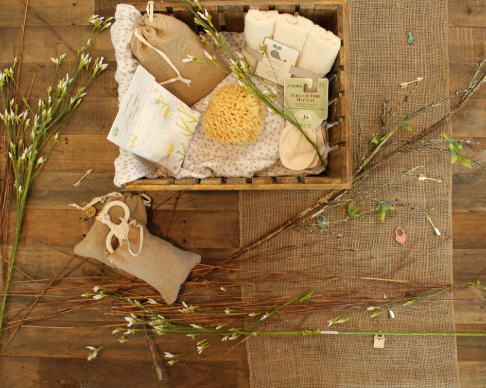 Rustic spa gift basket with organic skincare items and decorative branches.